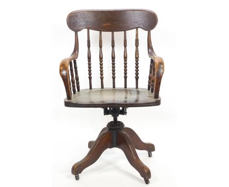 An elm and oak swivelling desk/office stick back swivel chair of traditional form with shaped over shaped arms on bobbin turn