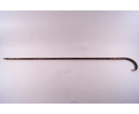 A cane walking stick of slim proportions with a 9 ct rose gold tip to the handle.