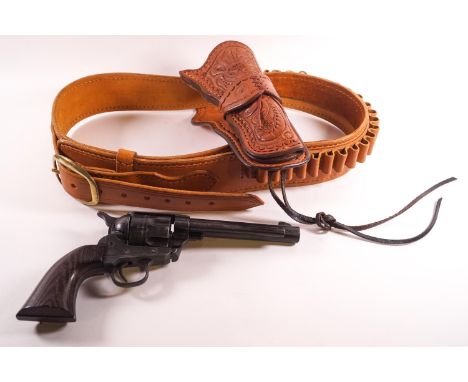 A tan leather holster belt with tooled decoration set with a replica colt single action army 45 gun
