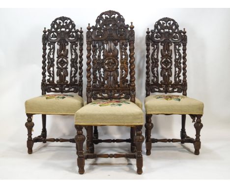A set of four carved oak dining chairs in the style of Daniel Marot, the tall backs with pierced and carved decoration of fol