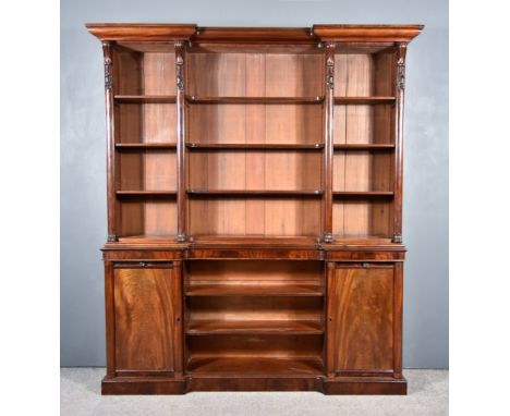 An Early Victorian Figured Mahogany Inverted Breakfront Bookcase, the upper part with moulded cornice, plain frieze, fitted n
