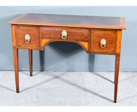 An Edwardian Mahogany Kneehole Dressing Table in the Sheraton Manner the top with wide satinwood banding, fitted three drawer