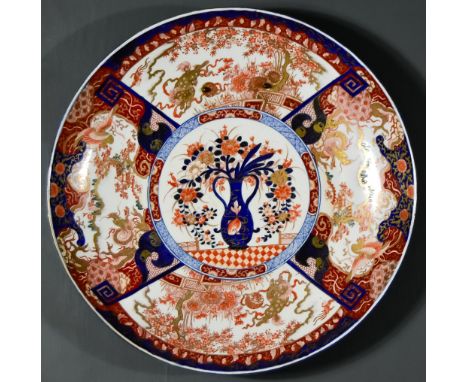 A Japanese Porcelain Imari Charger, enamelled in blue, orange, green and gilt with a central reserve of a vase of flowers, fl