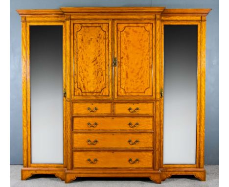 An Edwardian Satinwood Breakfront Wardrobe, the whole inlaid with rosewood bandings, with dentil moulded cornice, fitted four