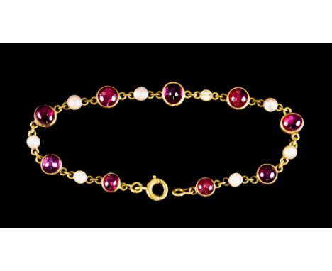 A 14ct Gold Ruby and Seed Pearl Bracelet, set with nine collet cabochon ruby stones interspaced eight small seed pearls, 180m