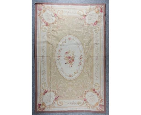 A French Aubusson Tapestry Carpet,&nbsp;woven in pastel shades with floral filled oval centre panel and leaf scroll field on 
