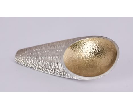 An Elizabeth II Silver and Silver Gilt Caddy Spoon, by Andrew Bird London 2021, of textured form with oval gilt bowl and tape