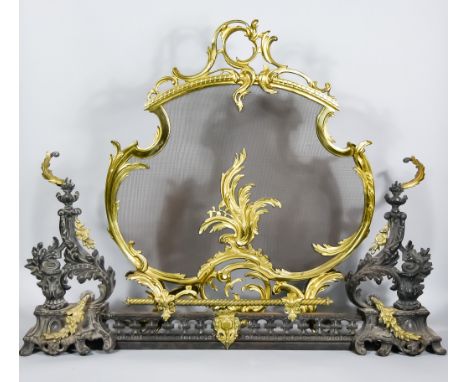 A Brass Fireguard of Rococo Design and a Fender with Chenets, the fireguard of cartouche shape and with leaf scroll mounts, o