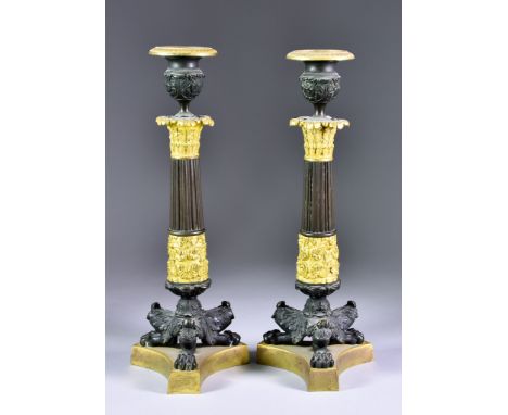 A Pair of 19th Century French Bronze and Ormolu Pillar Candlesticks of Empire Design, with reeded columns and each on three p