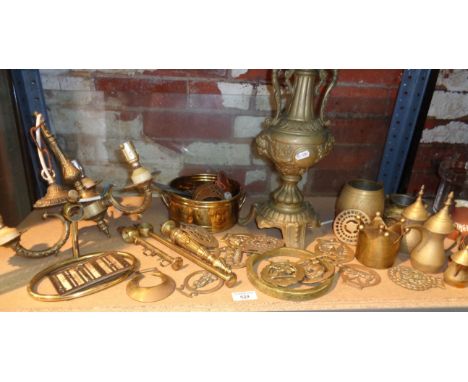 Shelf of assorted brassware, inc. horse brasses, table lamp, etc.