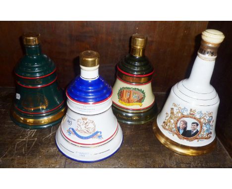 Four Wade china decanters full of Bell's Whisky
