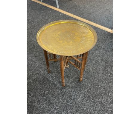 Vintage folding wooden based brass topped table measures approximately 21 inches tall 21 inches diameter 