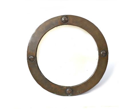 A Liberty & Co patinated brass wall mirror, circular stamped in relief with three Celtic roundels, applied Liberty label, 55c