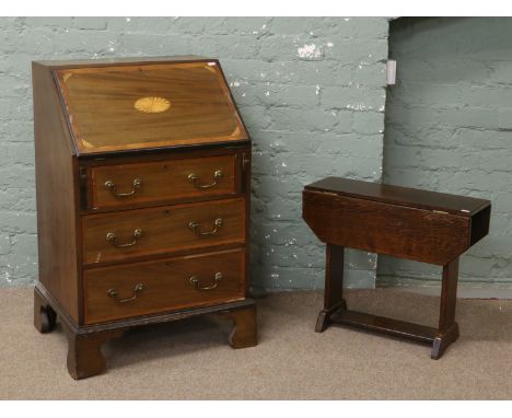 A mahogany bureau with marquetry inlay raised on bracket feet, along with an oak dropleaf occasional table.