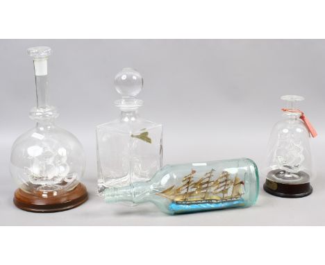 Three model ships in bottles, two spun glass and a square glass decanter.