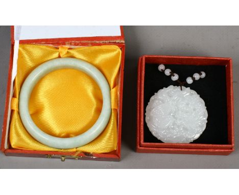 A modern Chinese celadon jade bangle together with a white jade pendant