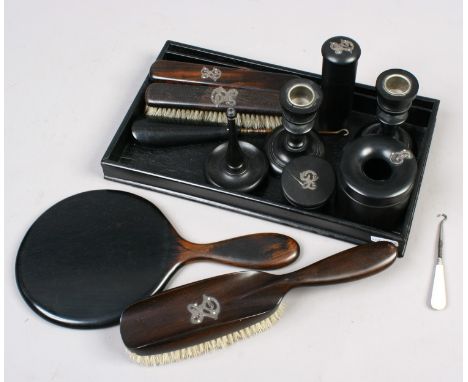 An ebonised dressing table set to include brushes, mirror, candlestick, shoe horn etc