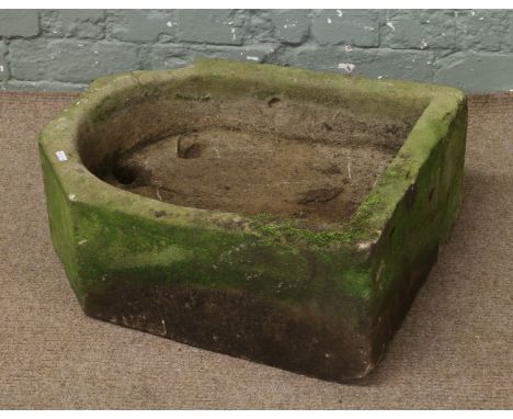 A carved stone sink later altered to a planter.