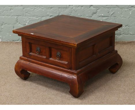 A Indonisian hardwood square shaped coffee table with storage drawers raised on bracket feet.