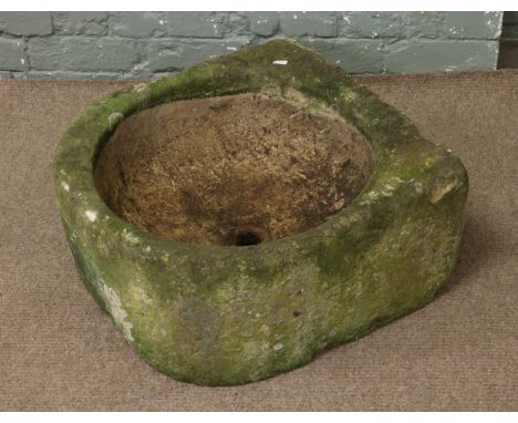 A carved stone sink later altered to a planter.