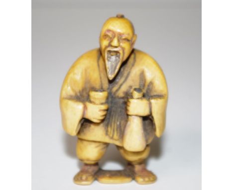 Antique Japanese ivory netsuke standing man with sake bottle. Signed to base. This item may not be exported without cites doc