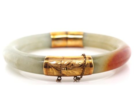 Chinese jade and gold bangle with a hinged mechanism with a marked 14k BT bright cut engraved gold hinge and clasp. Approx 10