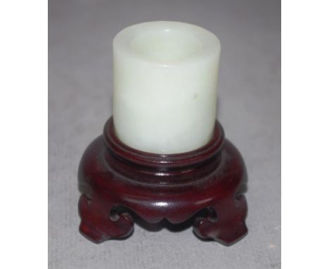 Good Chinese jade archers ring on a carved timber stand, height 6.5cm approx