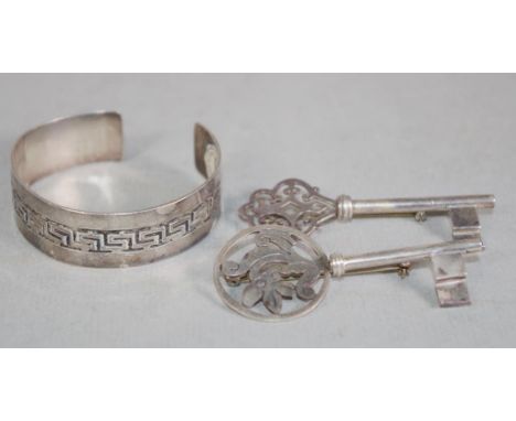 Two Mexican silver key brooches both stamped Mexico 925, together with a sterling silver Greek key bangle