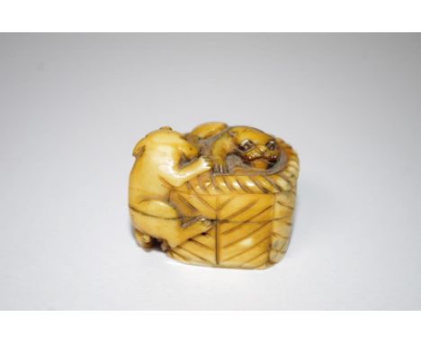 Antique Japanese ivory netsuke two dogs in a basket, signed to base. This item may not be exported without cites documentatio