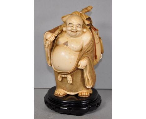 Antique Japanese carved ivory Hotei figure depicting Hotei (Chinese Putai), one of the seven gods. Figure standing with his s