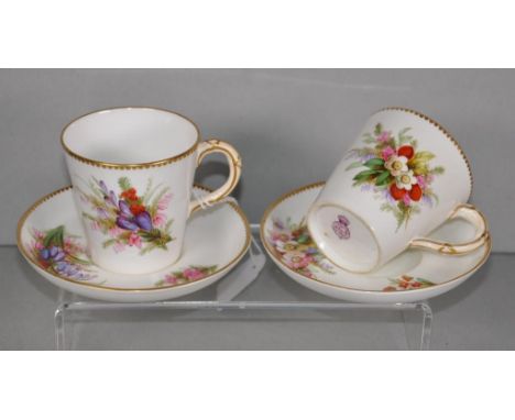 Two Victorian Royal Worcester cups & saucers hand painted floral decoration, gilded rims, marked to bases.