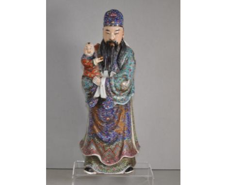 Chinese standing ceramic figure standing gentleman, wearing extensively decorated robes, with child in arms. Inscribed charac