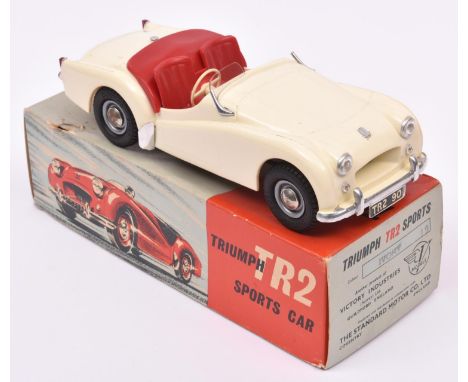 A Victory Industries 1:18 scale battery operated model of a Triumph TR2. Moulded plastic body in ivory, with red interior. In