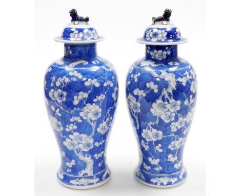 A pair of late 19thC Chinese porcelain baluster vases and covers, each decorated with flowering prunus trees, four character 