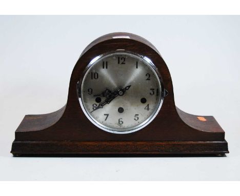 A 1930s oak cased Nelsons hat mantel clock, the silvered dial showing Arabic numerals, eight day movement with Westminster ch