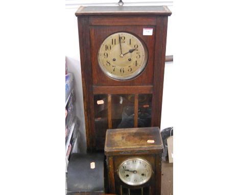 A circa 1920s oak drop trunk wall clock, together with similar mantel clock, and an ebonised oak mantel clock (3)