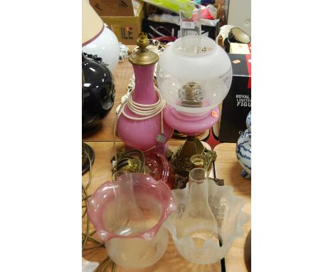 A Victorian cranberry glass lamp font, together with various other lamp parts