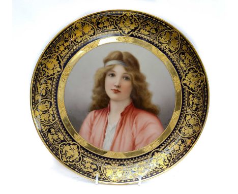 A pair of early 20th century Vienna plaques, each with a wide cobalt blue and tooled gilt border, and painted with a portrait
