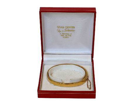 A hinged bangle, stamped '15', inner measurements 6.1cm by 5.1cmGross weight 11.6 grams.