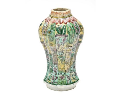 A Chinese Porcelain Vase, Kangxi, of fluted oval section baluster form, painted in famille verte enamels with panels of folia