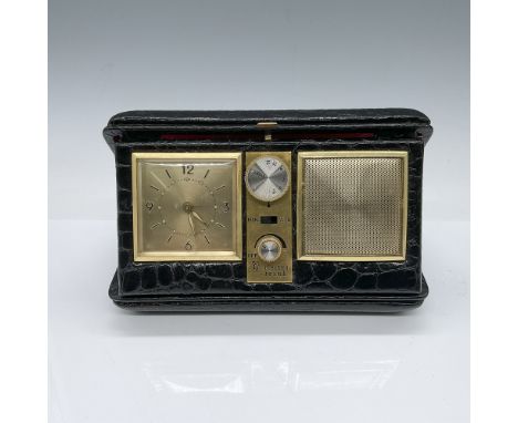 A vintage Electro Brand alarm clock radio featuring a sleek black and gold design, enclosed in a black leather-textured case 