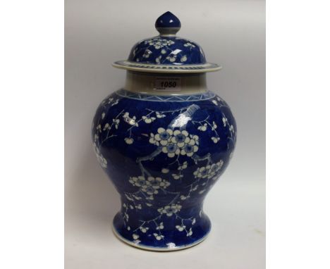 A Chinese ginger jar, decorated with blossoming prunus on a blue cracked ice ground, domed cover, knop finial, six character 