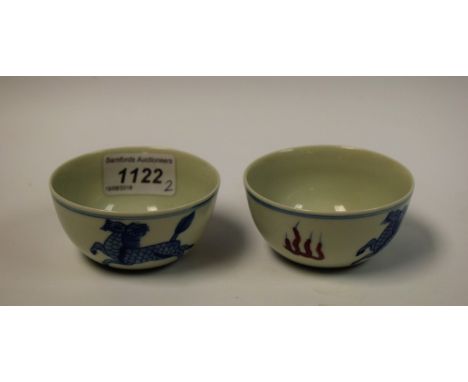 A pair of Chinese porcelain circular tea bowls, painted with longma in underglaze blue and flanked by stylized flames painted