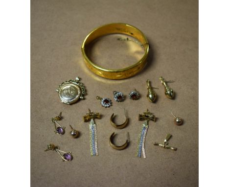 A rolled gold hinged bangle, engraved; a pair of yellow metal earrings, with conforming pendant; others, similar