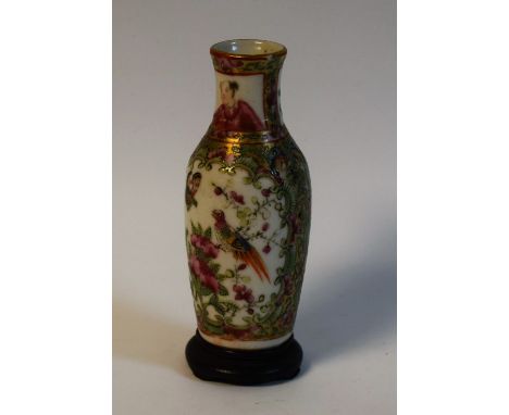 A small Chinese famille verte baluster vase, painted with figures in a stylized interior in a C-scroll reserve in colourful p
