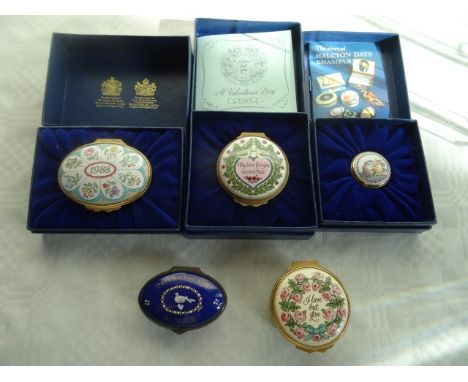 Three boxed Halcyon Days enamel pill boxes, together with two further unboxed pill boxes.