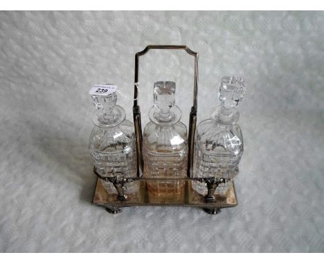 A three bottle decanter set in fitted silver plated stand with handle.