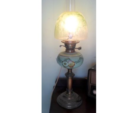 A Victorian green glass and brass oil lamp, later converted to electricity, the glass reservoir having hand painted floral de