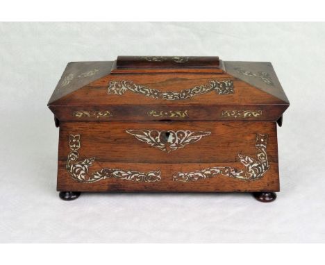 A rosewood and mother of pearl inlaid tea caddy of sarcophagus form, having twin internal red lined compartments and associat