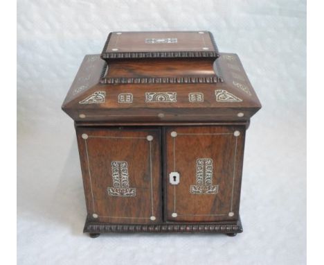 A Victorian mother of pearl inlaid jewellery box of sarcophagus form, having covered compartments to the upper section over t